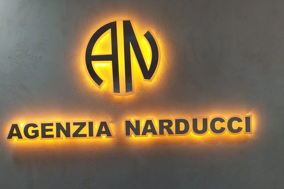 Il logo dell'Agenzia Narducci illuminato sulla parete dell'ufficio