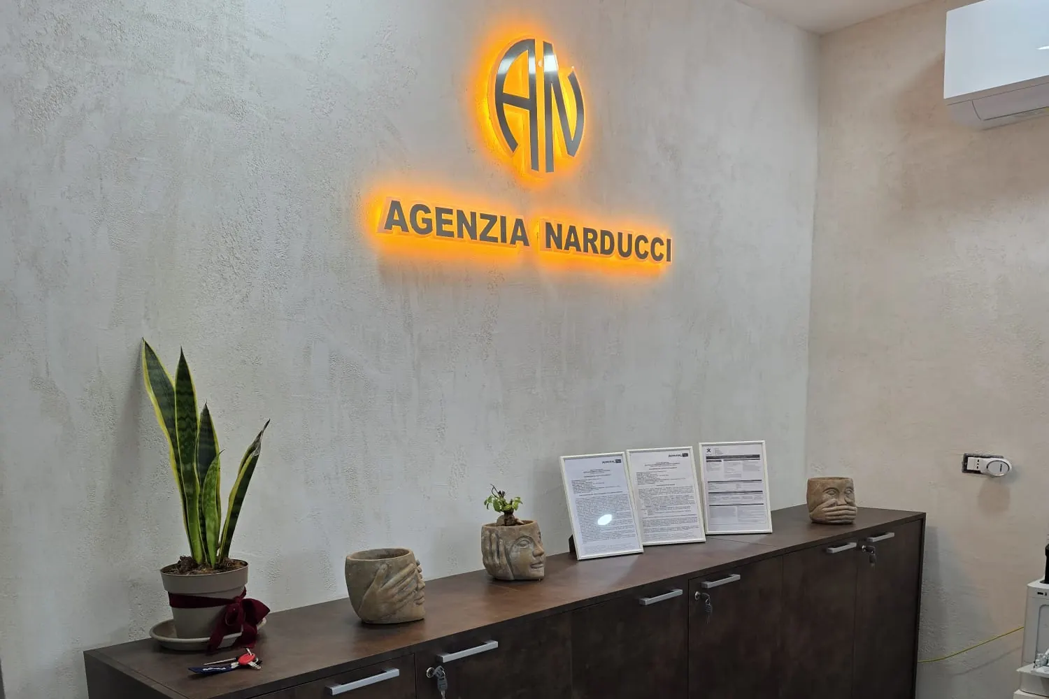 La parete della reception dell'Agenzia Narducci, col logo illuminato